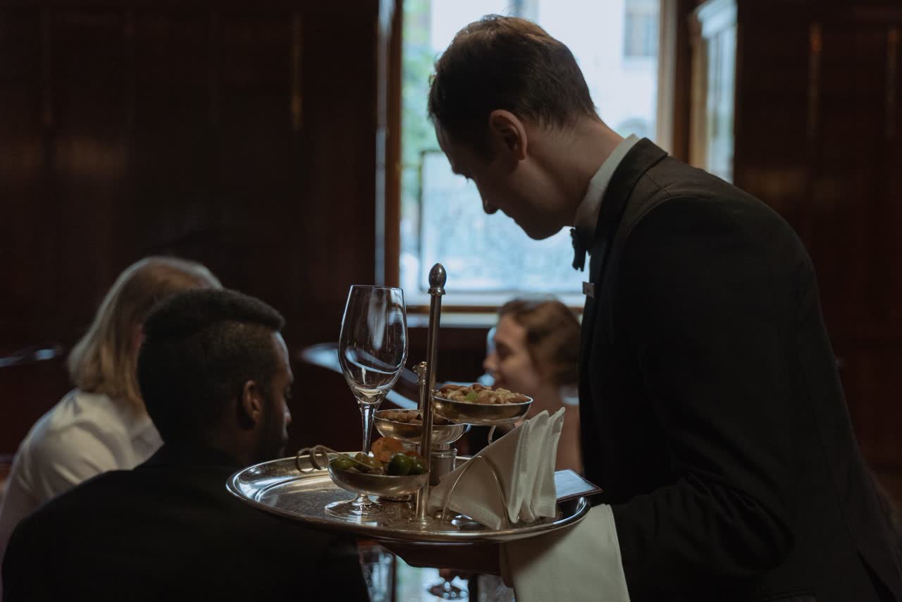 A server presenting dishes to the table